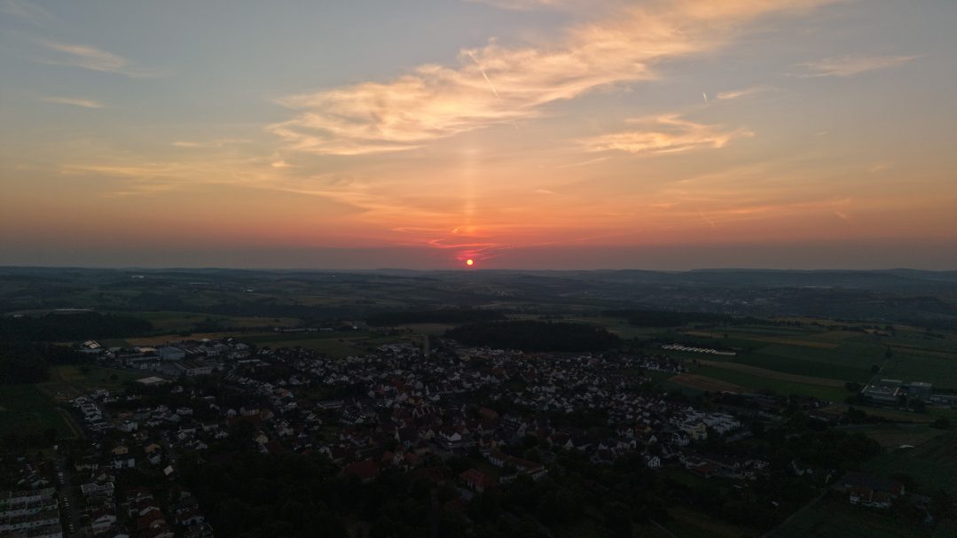 Abendstimmung bei Leonberg – Sonnenuntergang mit sichtbaren Kondensstreifen, die den Himmel durchqueren, während die Landschaft in Dunkelhei