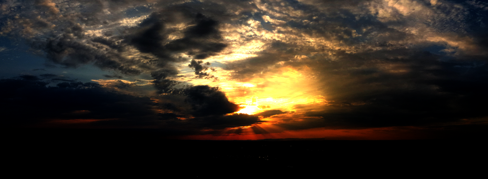 Ein unerwartet turbulenter Abend bei Bürg Sonnenuntergang über Bürg mit dunklen Wolken und hellen Sonnenstrahlen am Horizont