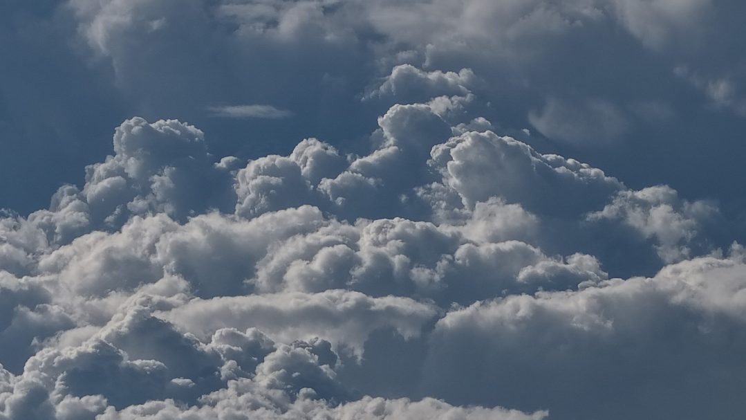 Dicht gestaffelte, hoch aufgetürmte Gewitterwolken – der gesamte Himmel erscheint wie eine brodelnde Wand aus Wasserdampf und Energie.